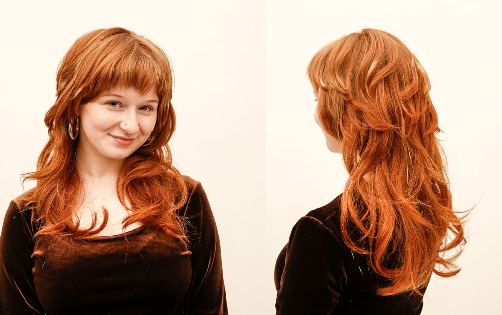 A hair stylist with voluminous red wavy hair 