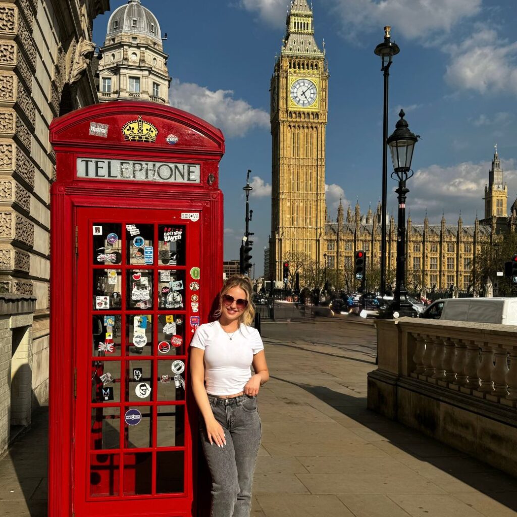 Casandra posing by a red telephone booth in London