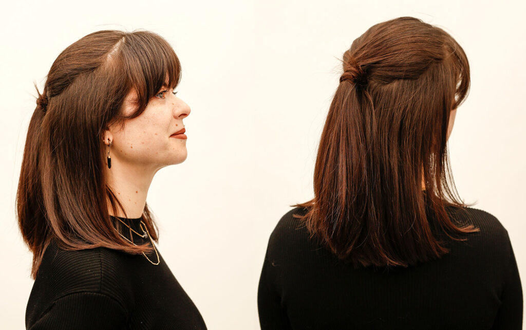 A hair stylist with her sleek, straight hair pulled back in a half-up wrap ponytail